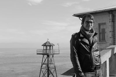 Portrait of man standing by railing against sky