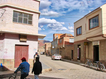 Rear view of people on street amidst buildings in city