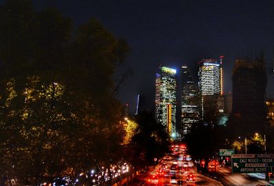 Illuminated city against sky at night