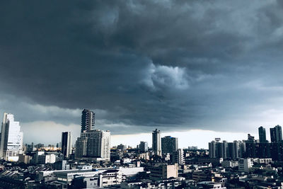 Buildings in city against cloudy sky