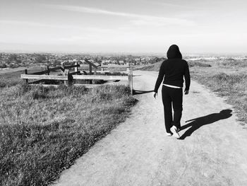Rear view of woman standing against sky