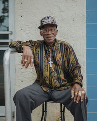 Portrait of old man standing against wall in cuban neighbord