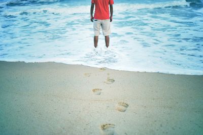 Low section of woman walking on beach