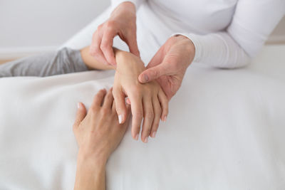 High angel view of woman holding patient hand in hospital