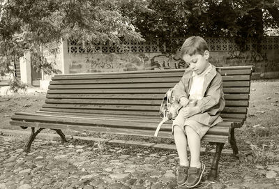 Boy sitting on bench in park
