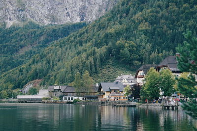 Scenic view of lake by buildings against mountain