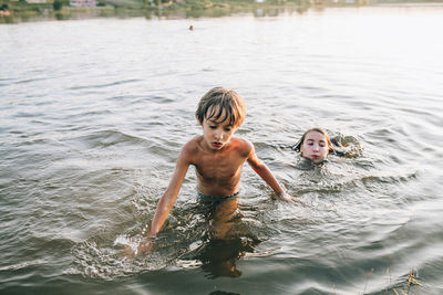 Cute sibling playing in river