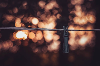 Close-up of clothespin hanging on clothesline at night