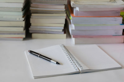 Close-up of pen on open blank book at table