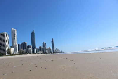 View of beach and buildings against clear sky