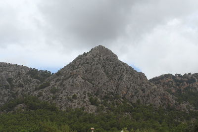 Low angle view of rocky mountain against sky