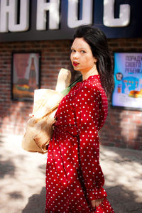 Portrait of young woman standing on street