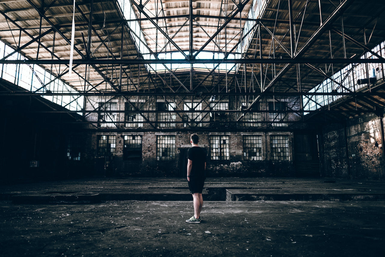 full length, lifestyles, built structure, architecture, standing, leisure activity, casual clothing, rear view, walking, indoors, day, building exterior, person, side view, wall - building feature, metal, graffiti