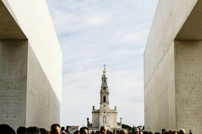 Tourists in front of cathedral against sky