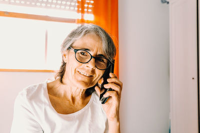 Mature woman talking on phone at home