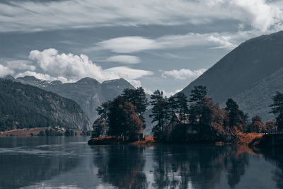 Scenic view of lake and mountains against cloudy sky