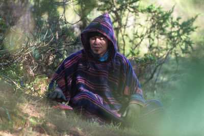 Portrait of colombian native american man in traditional clothing in forest