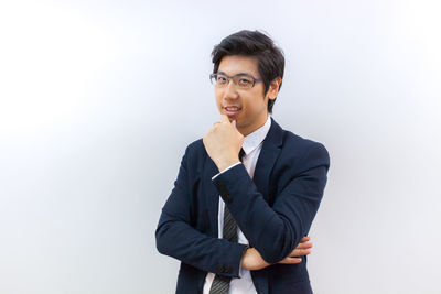 Young man standing against white background