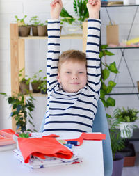 Close-up of caucasian boy who studie to sew with a needle and thread, additional education, leisure.