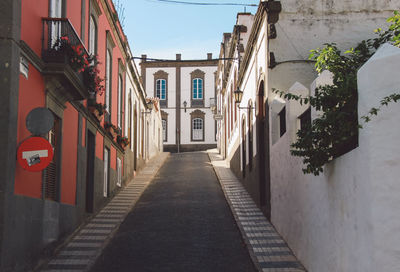 Walkway amidst buildings in city