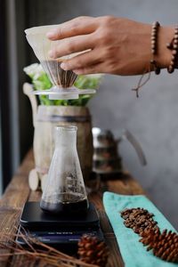 Cropped hand of barista making coffee in cafe