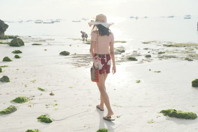 Rear view of woman walking on beach