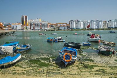 Boats moored on beach against buildings in city