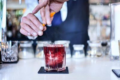 Close-up of bartender preparing cocktail at counter