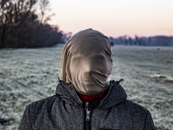 Portrait of man wearing scarf against sky during winter