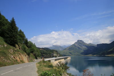 Scenic view of lake by mountains against sky