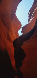 Low angle view of rock formation against orange sky