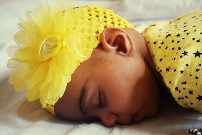 Close-up of baby girl sleeping on bed