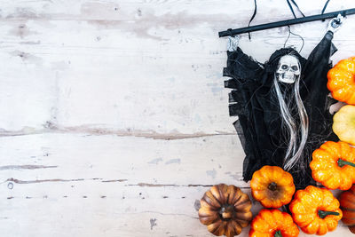 Directly above shot of human skull with decoration and pumpkins on table