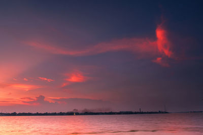 Scenic view of sea against dramatic sky during sunset