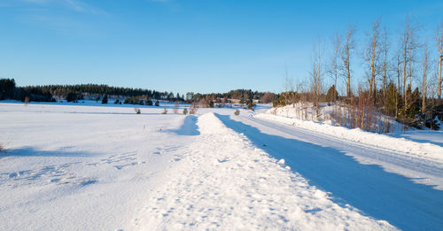 Scenic view of snow covered field against sky