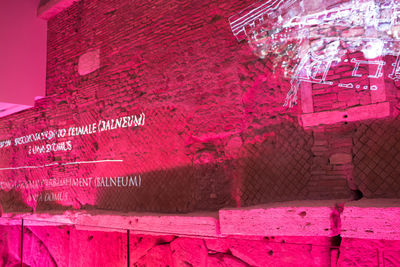 Close-up of text on pink brick wall