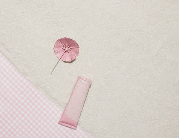 High angle view of umbrella with pool raft and blanket on sand at beach