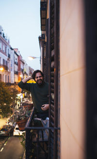 Cheerful man standing in balcony