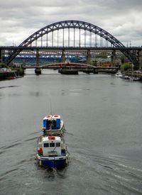 Bridge over river against cloudy sky