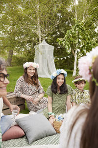 Family wearing flower wreaths at picnic