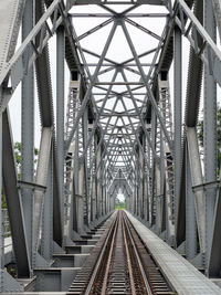 Perspective view of the steel railway bridge is crossing the large river.