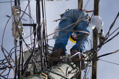 Directly below shot of electrician on electricity pole