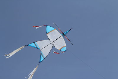 Low angle view of kite flying against clear blue sky