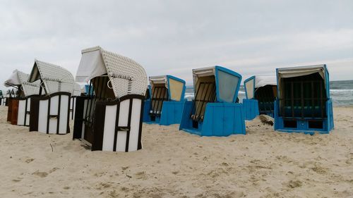 Lounge chairs on beach against sky