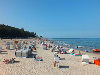 Group of people on beach against clear sky