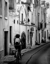 Rear view of man cycling on road