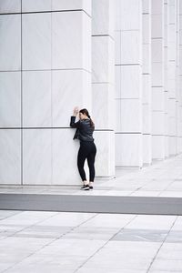 Full length of man standing against wall