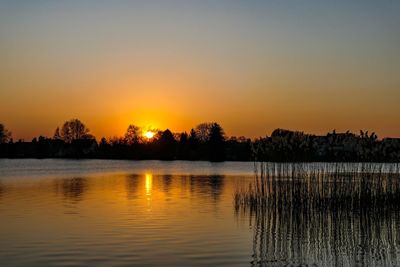 Scenic view of lake against romantic sky at sunset