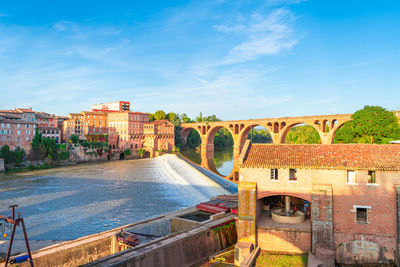 Bridge over river against buildings in city