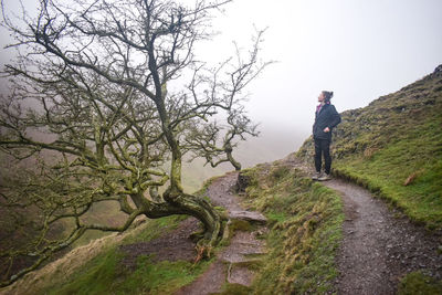 Full length of young woman standing on mountain